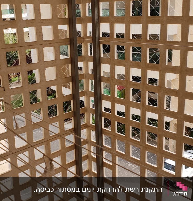 רשת מתכת על קיר למניעת כניסת יונים